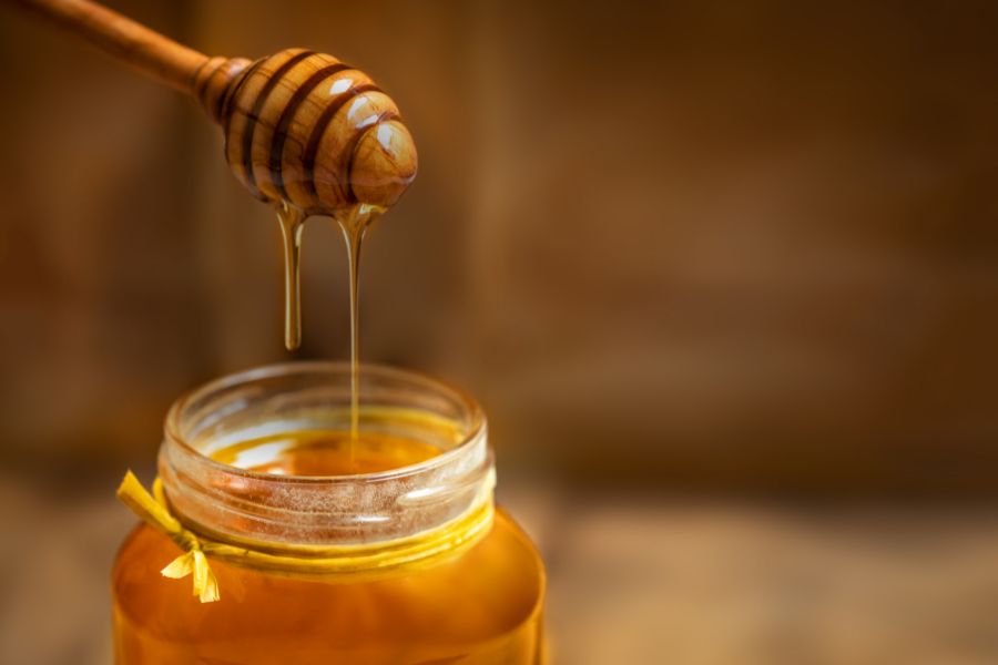 Honey in glass jar and honey dipper